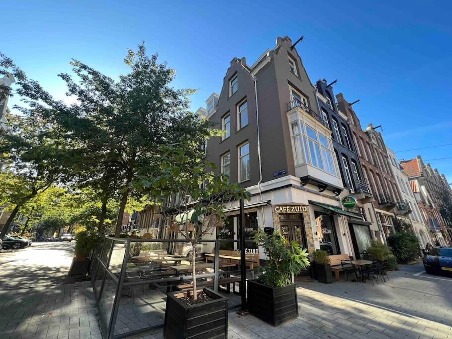 budynek na ulicy ze stołami i drzewami w obiekcie Vondelpark Luxury Apartment w Amsterdamie