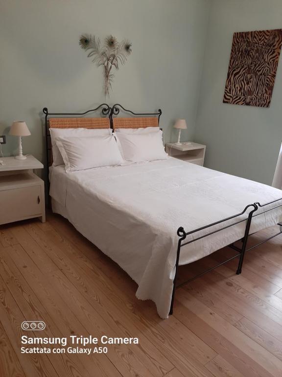 1 dormitorio con 1 cama grande con sábanas blancas en B&B A Casa Tua, en Asís
