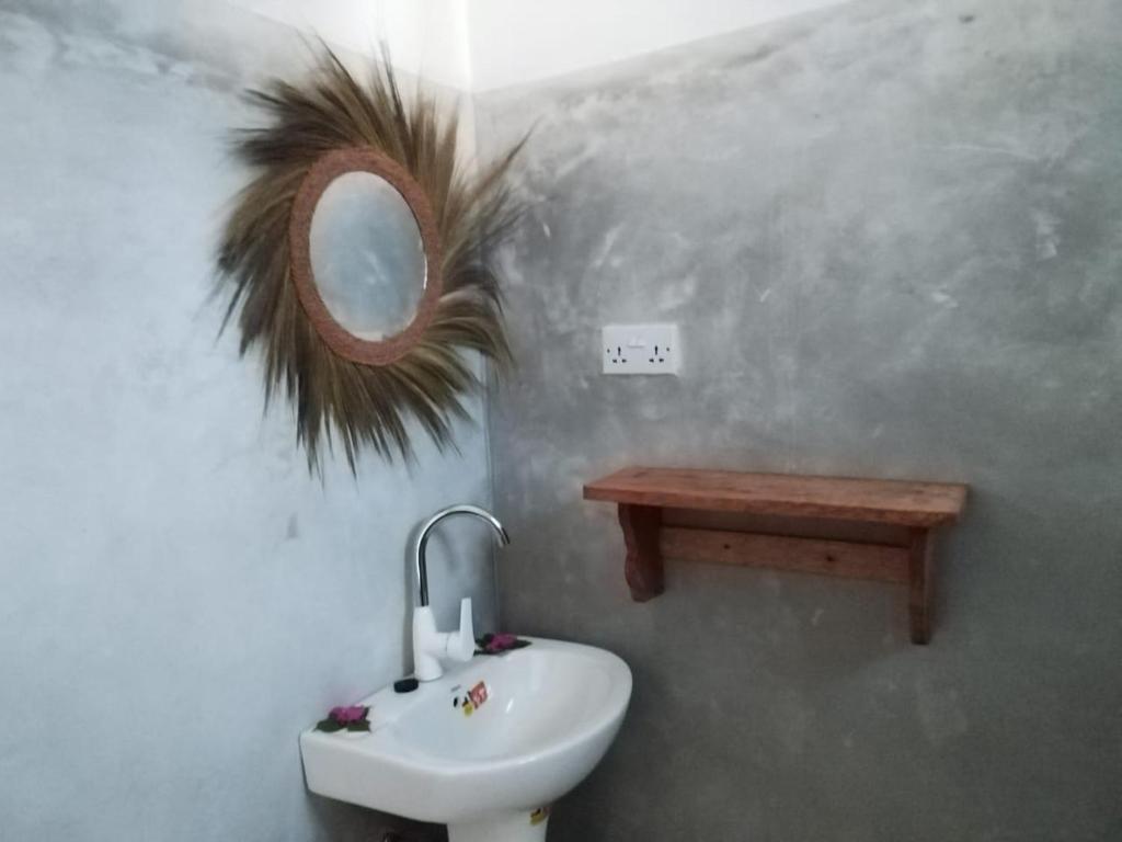 a bathroom with a sink and a mirror on the wall at Pamoja Beach Stays Hotel in Jambiani in Jambiani