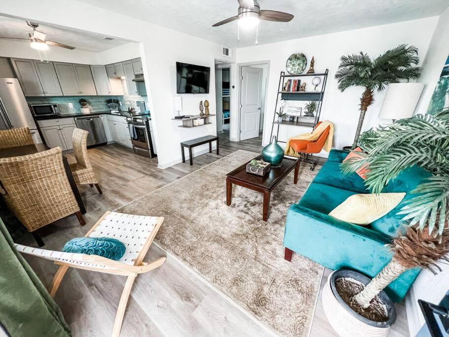 uma sala de estar com um sofá azul e uma cozinha em Moody Gardens Oasis (Unit 8) em Galveston