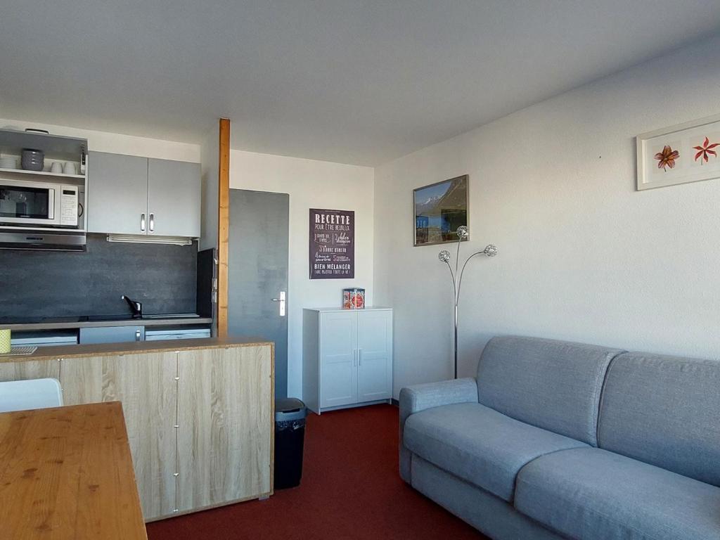 un salon avec un canapé et une cuisine dans l'établissement Appartement 2 pièces avec piscine, proche télécabine aux Arcs 1800 - FR-1-411-840, à Bourg-Saint-Maurice