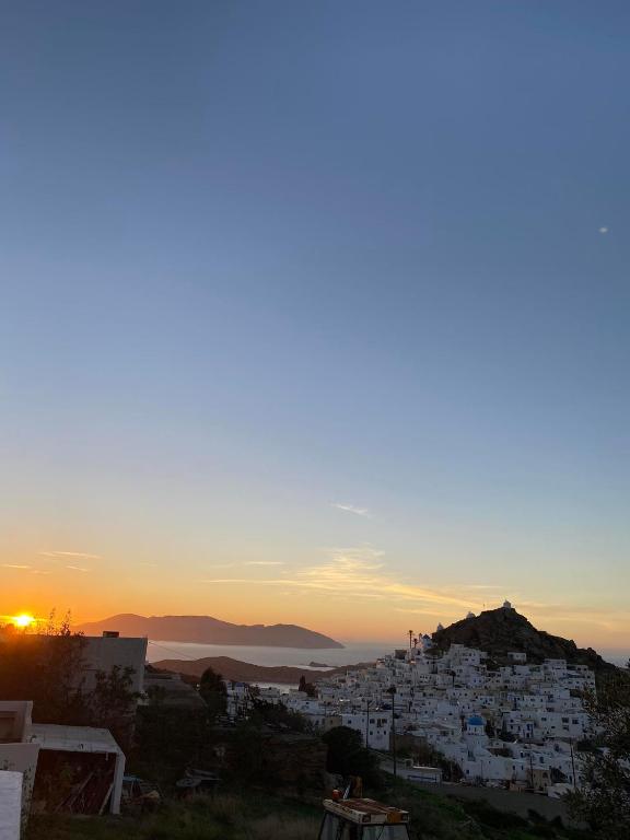 a sunset over a city with white buildings at Ios Village View in Ios Chora