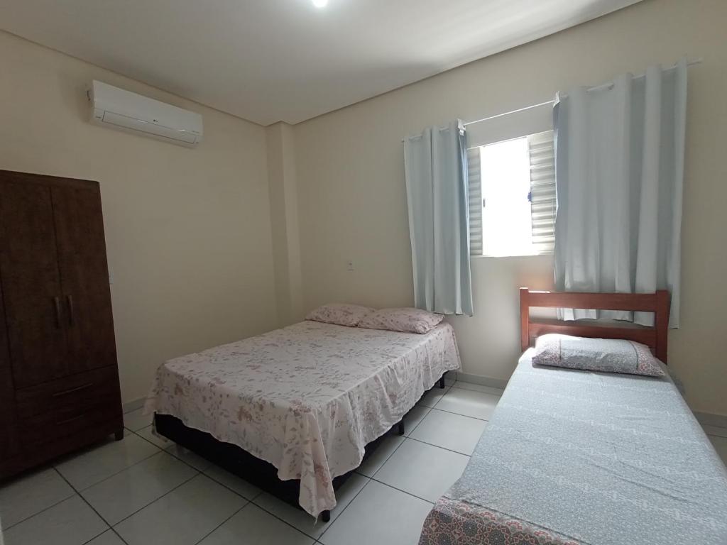a bedroom with two beds and a window at Apartamento Aconchego da Serra Azul in Barra do Garças
