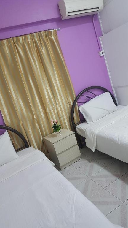 Postel nebo postele na pokoji v ubytování New Orchid Hotel Tuaran