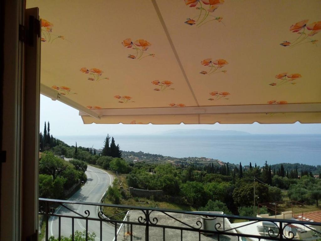 a view of a road from a balcony with an umbrella at Maria's Sea View Apartments in Mousata