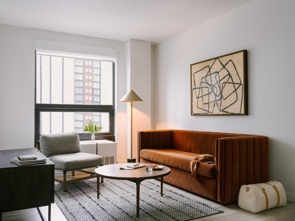 a living room with a couch and a chair and a table at Sonder Court Square in Long Island City