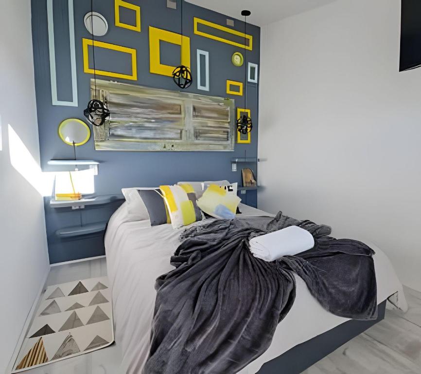 um quarto com uma cama com paredes amarelas e azuis em okeyloft Coyhaique 1 em Coihaique