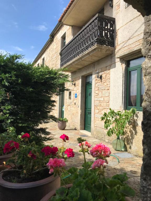 un edificio con una puerta verde y algunas flores en Casa A Canteira, en Vimianzo