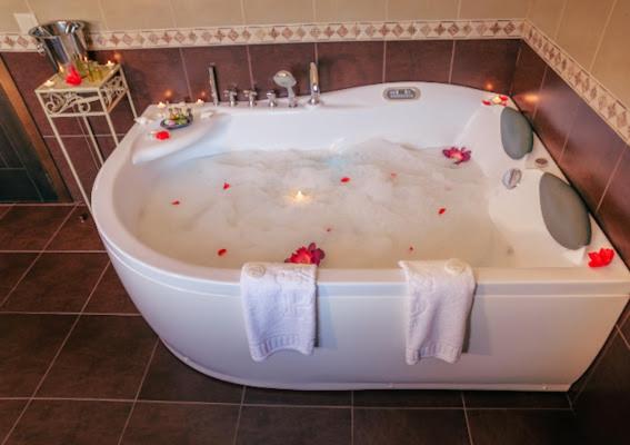 El baño incluye una bañera blanca con velas. en Casa A Canteira, en Vimianzo