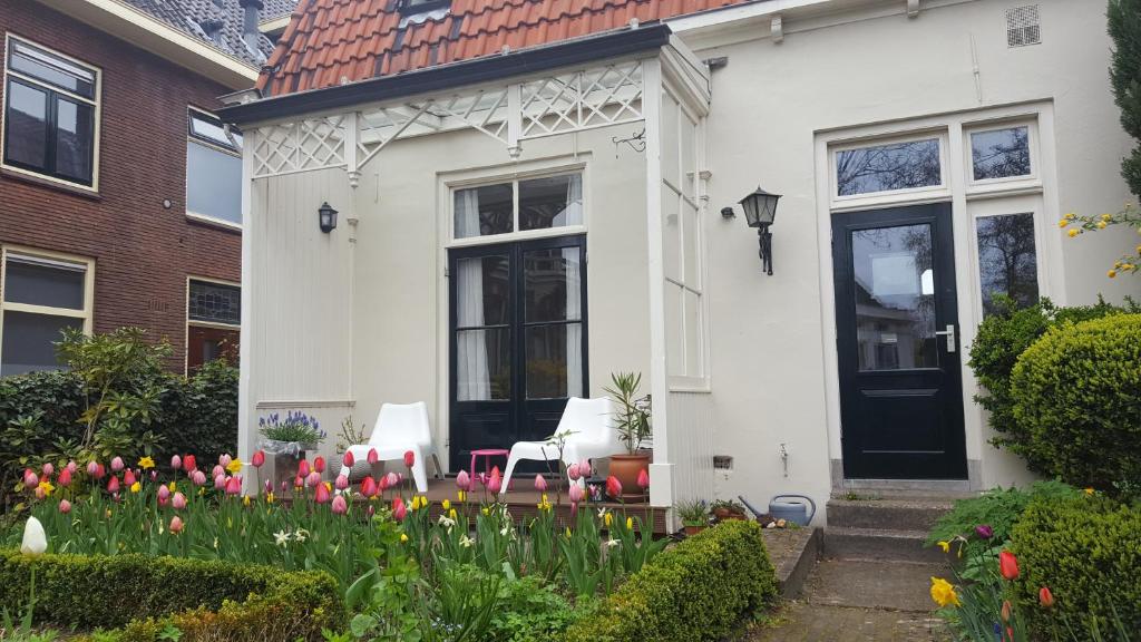 une maison blanche avec des fleurs devant elle dans l'établissement Het Zwolse Huisje, à Zwolle