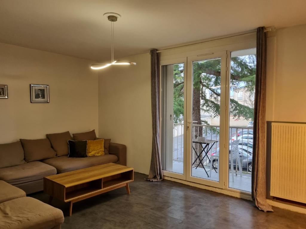 uma sala de estar com um sofá e uma porta de vidro deslizante em Cathédrale, champagne near, park and stores close em Reims