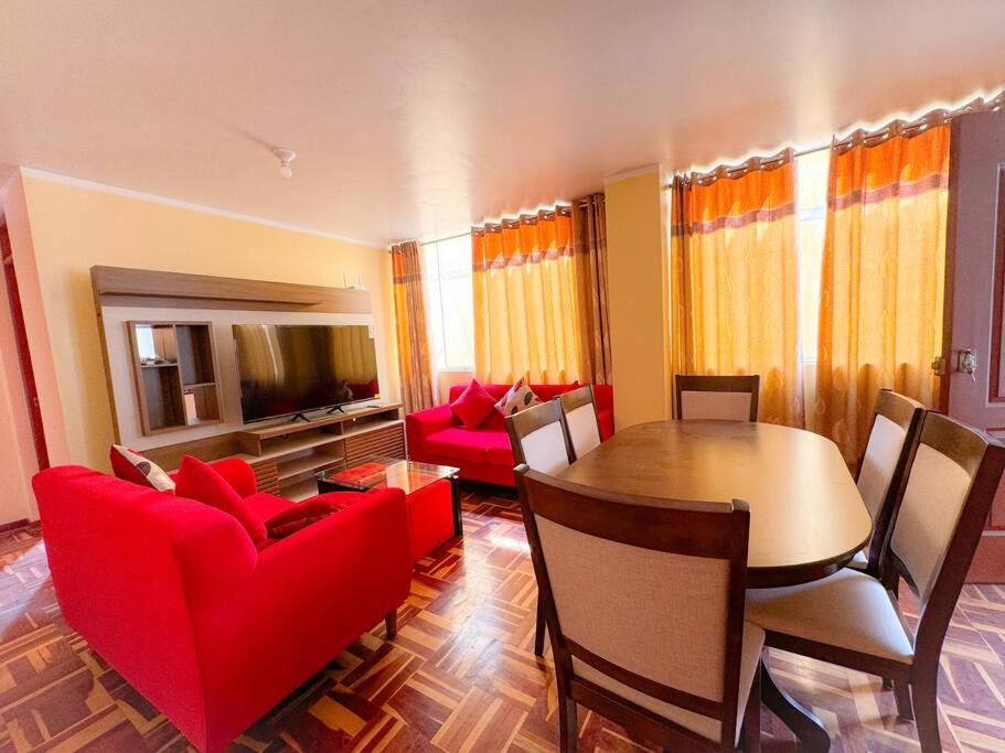 ein Wohnzimmer mit einem Tisch und roten Stühlen in der Unterkunft Acogedor y lindo Departamento en estreno in Lima