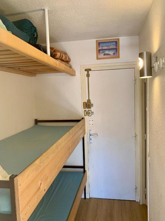 a small room with a bunk bed and a door at Studio Cabine Chaleureux 4 Personnes Pied des Pistes Pyrénées 2000 in Bolquere Pyrenees 2000