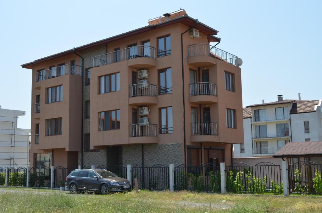 a building with a car parked in front of it at Guest House Georgievi in Primorsko