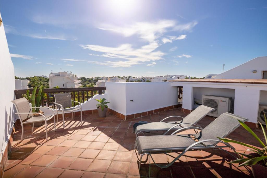 a patio with chairs and a fireplace on a balcony at Marina Dor III -Villa #10 Studio in Santanyi