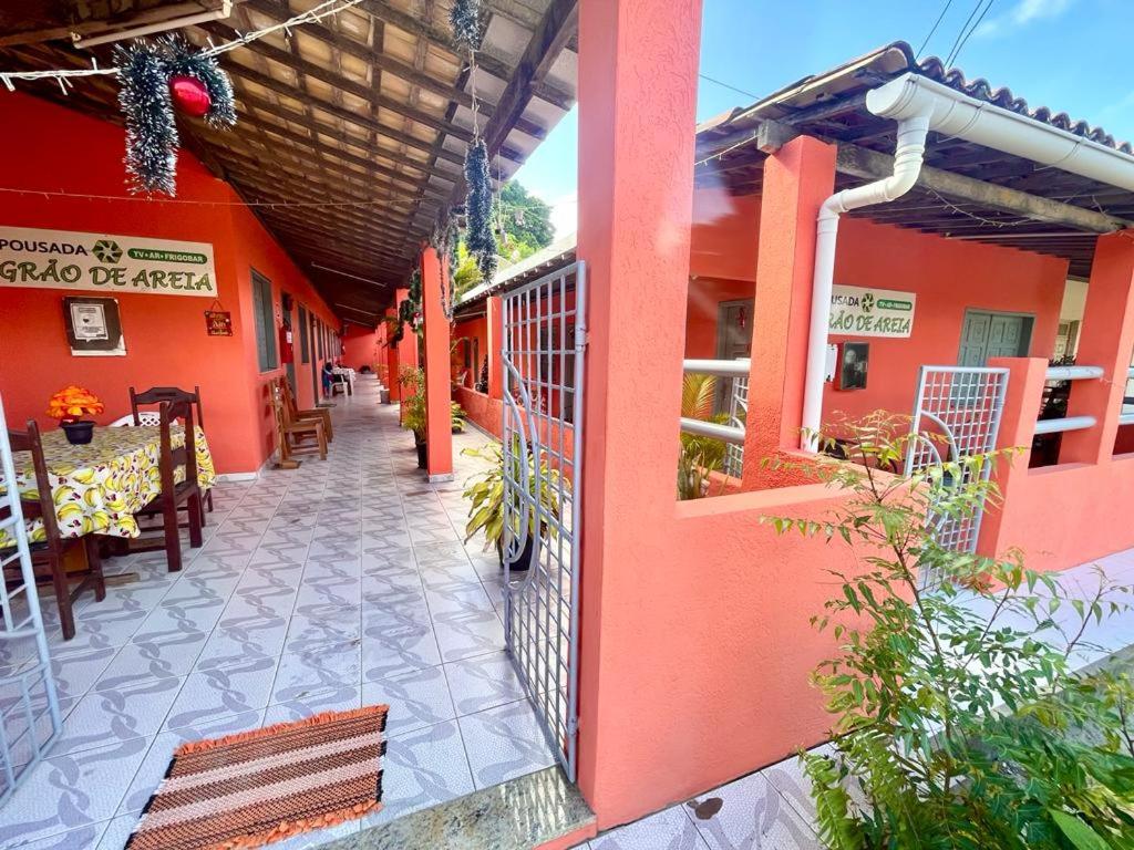 an open door of a building with a table and chairs at Graos de Areia Pioneira in Mangue Sêco