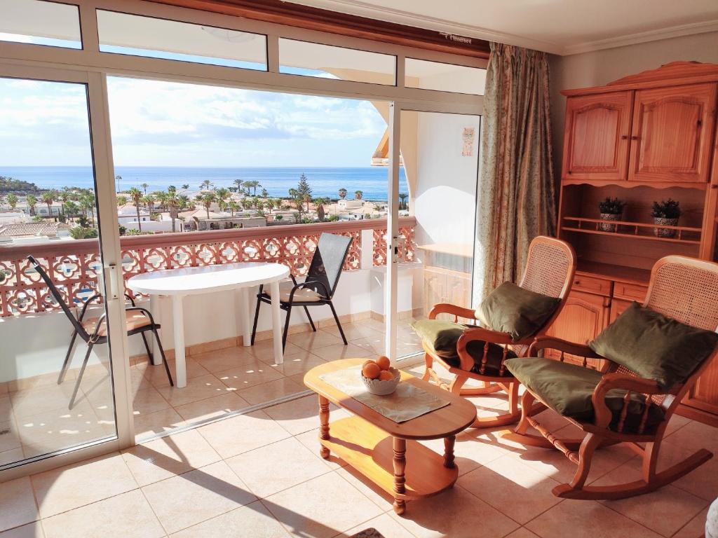 a living room with a balcony with a view of the ocean at Tenerife Flamingo in Palm-mar