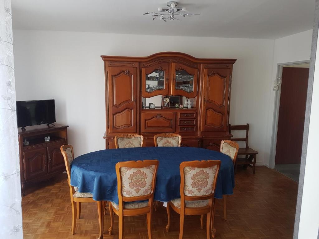 a dining room with a blue table and chairs at Belle Appartement in Auxerre