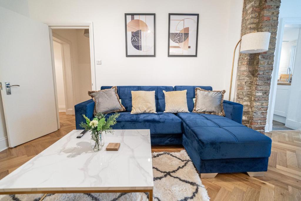 a blue couch in a living room with a table at One-bed flat Angel, Islington in London