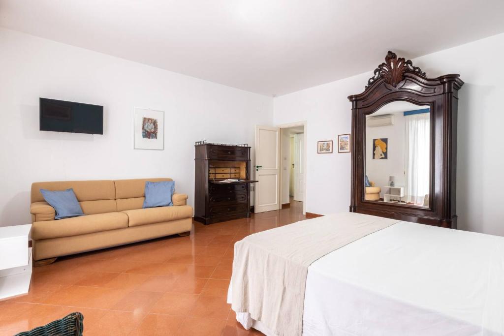 1 dormitorio con cama, espejo y sofá en Charming bedroom in Sorrento with balcony, en Sorrento