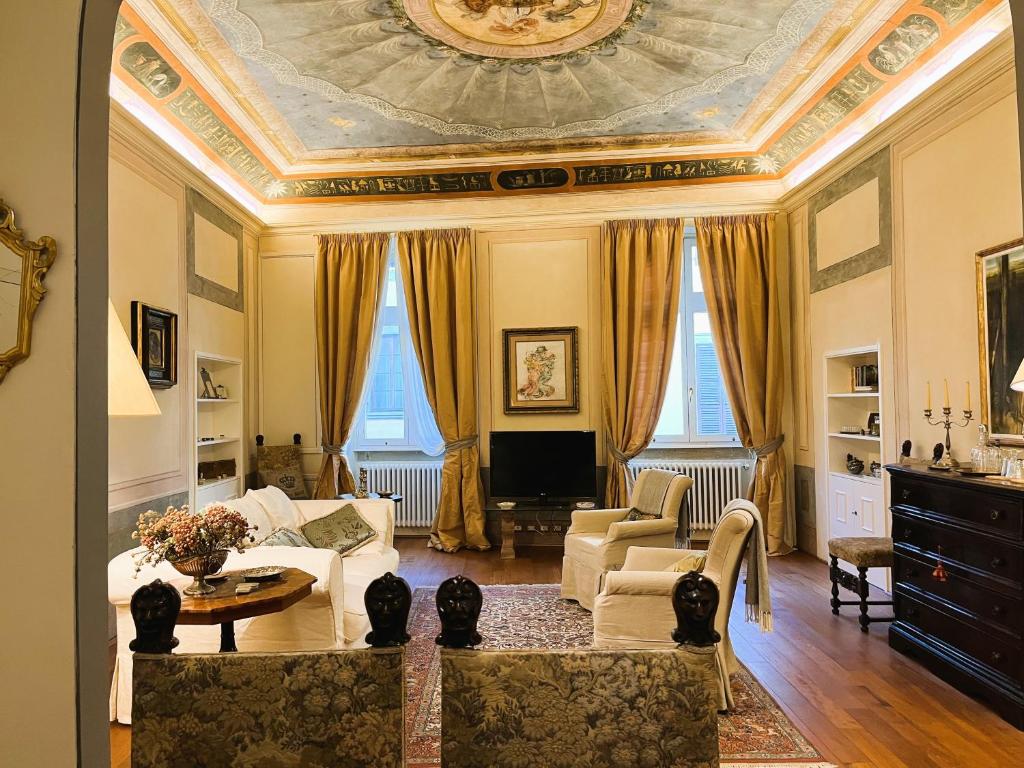 un soggiorno con soffitto a cassettoni e un soggiorno con divano. di Lusso e Charme! a Firenze