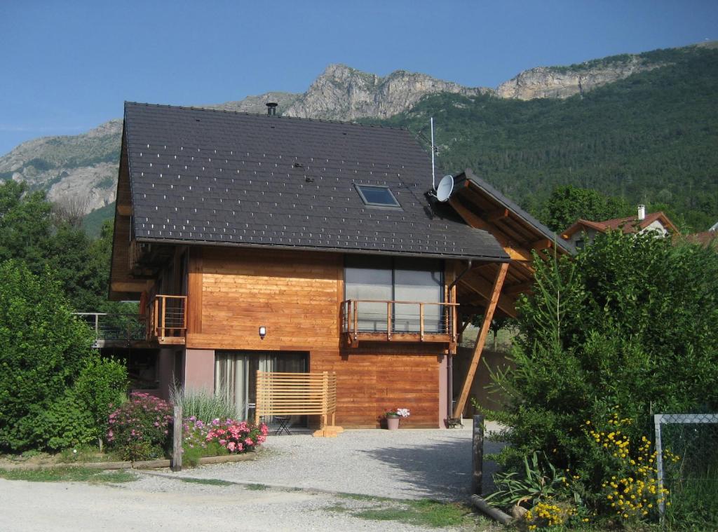 a wooden house with a balcony and mountains in the background at Studio Clos de Charance in Gap