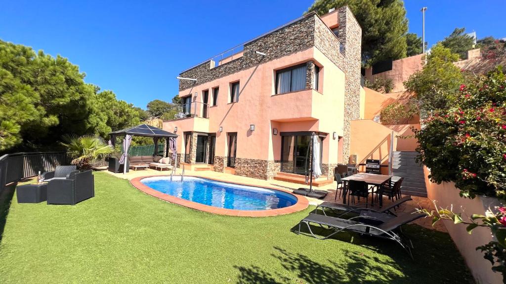 una casa con un patio con piscina en Villa Marina, en Lloret de Mar