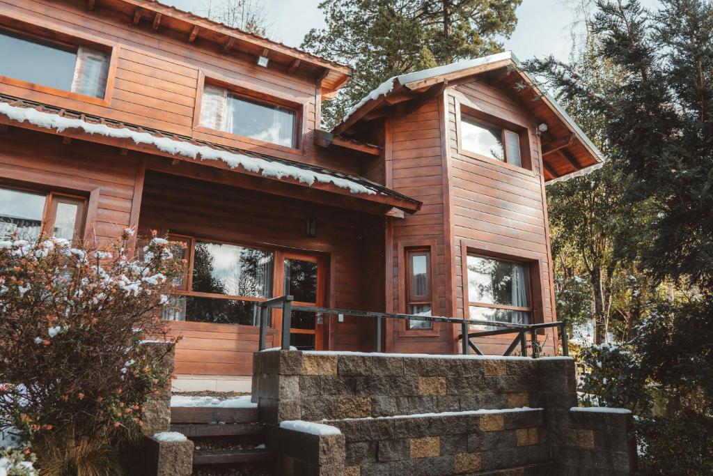 Cabaña de madera con escaleras que conducen a la puerta principal en Cabañas Bosque del Nahuel, en San Carlos de Bariloche