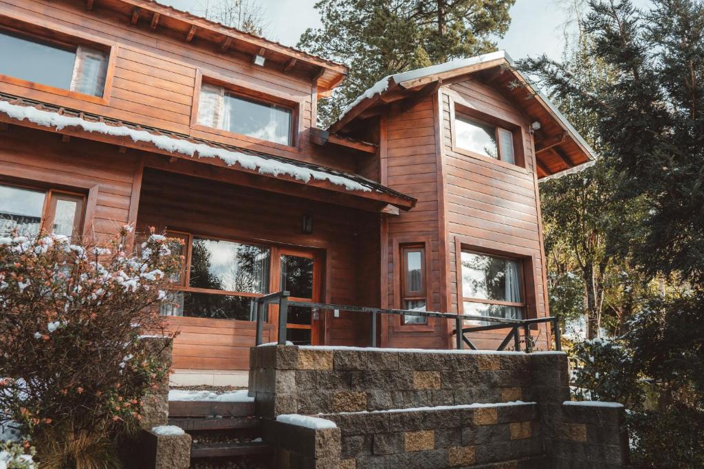 Cabaña de madera con escaleras que conducen a la puerta principal en Cabañas Bosque del Nahuel en San Carlos de Bariloche