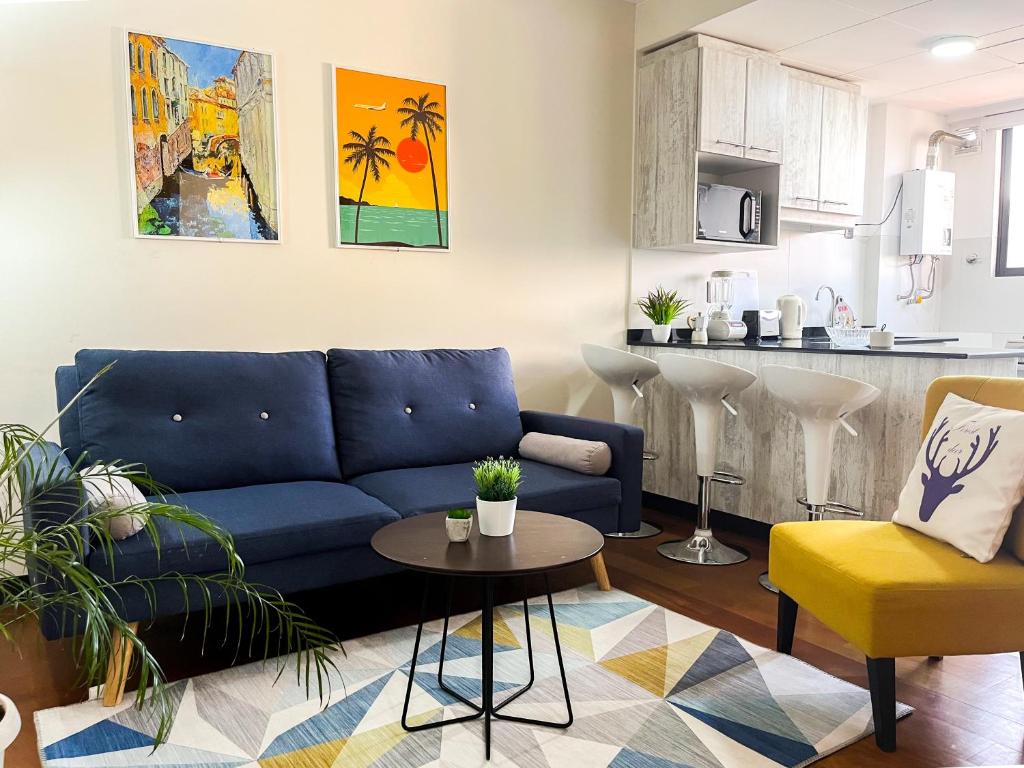 a living room with a blue couch and a kitchen at Warm, Bright & Cozy Apartment in the best area of La Paz! in La Paz