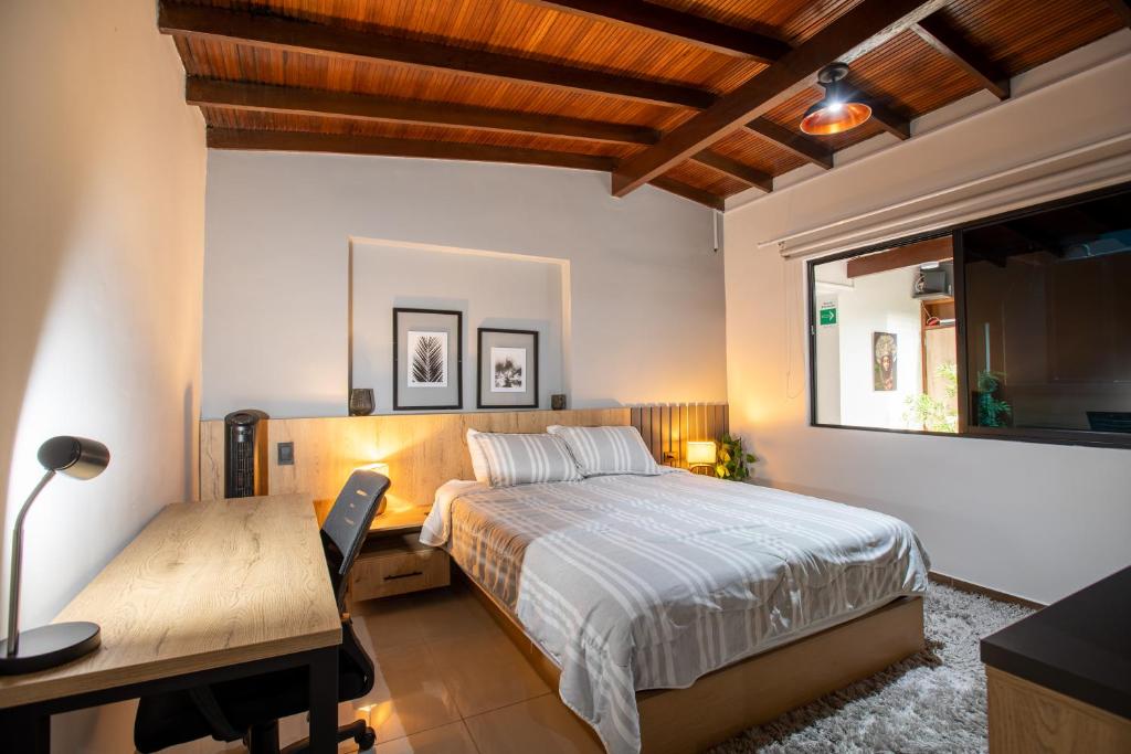 - une chambre avec un lit, un bureau et une fenêtre dans l'établissement Level Coliving, à Medellín
