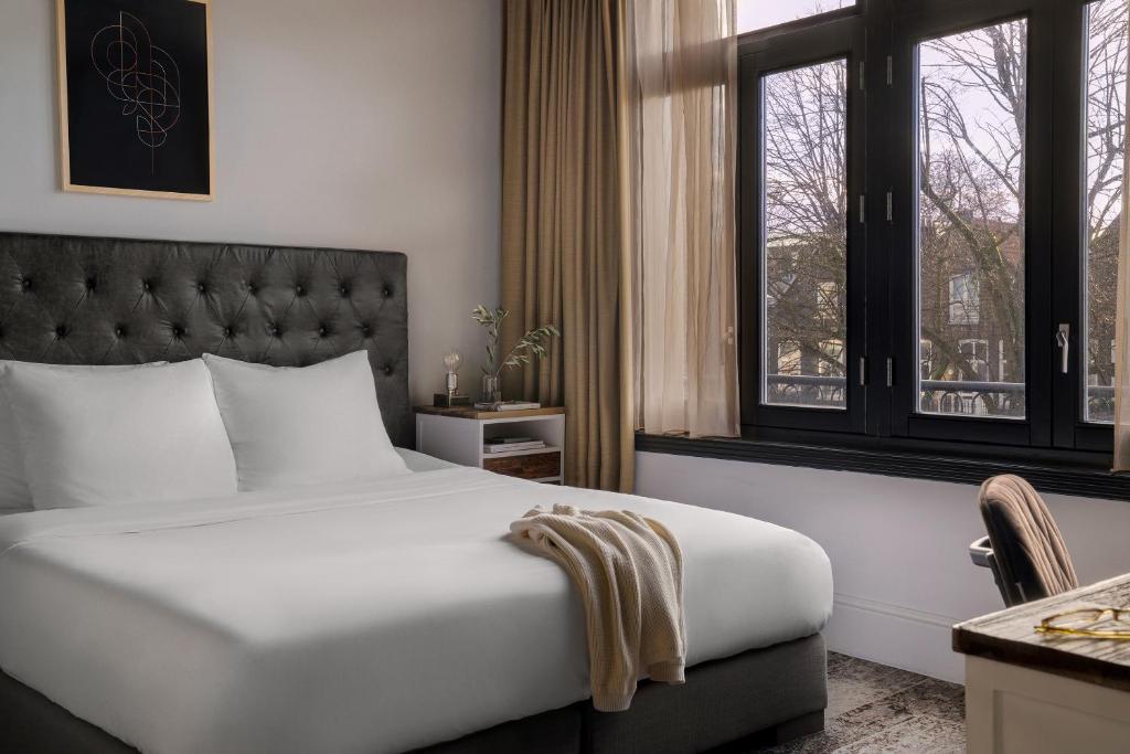 una camera d'albergo con letto e finestra di Sonder Park House ad Amsterdam