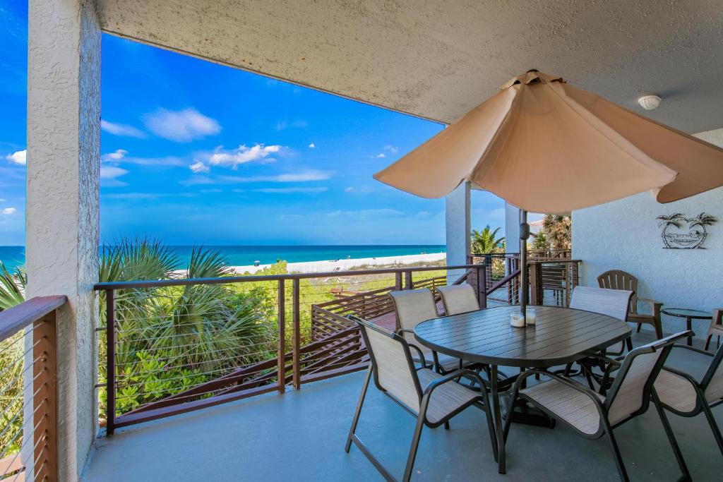 balcón con mesa, sillas y vistas al océano en The Reefs Edge, en Holmes Beach