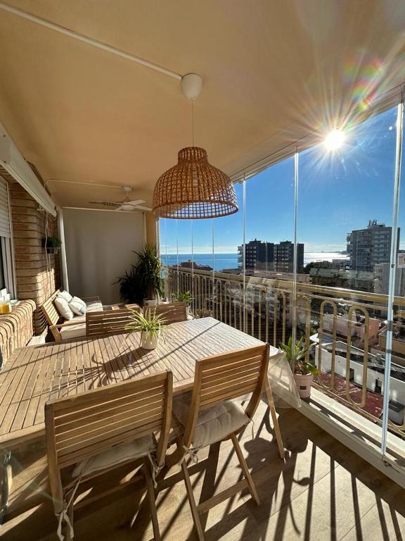 a dining table and chairs in a room with a balcony at Apartamento Benicàssim Sunset Calm&Views in Benicàssim