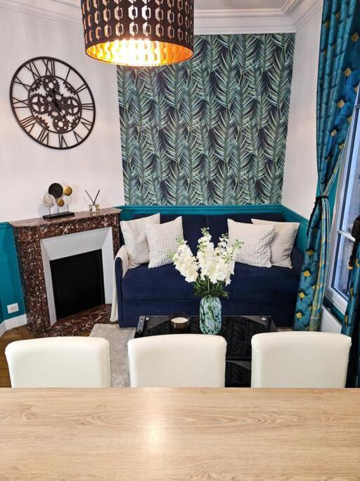sala de estar con sofá azul, mesa y sillas en French Luxury Paris en París
