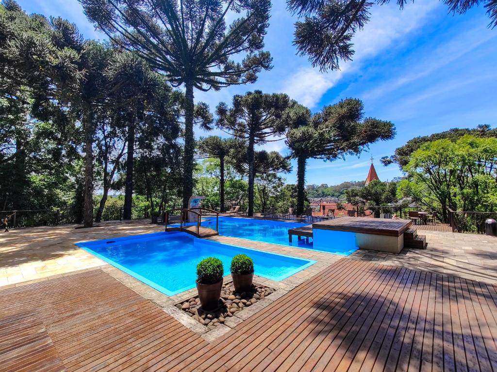 una piscina con árboles en el fondo en Hotel Serrano Gramado - Apto Particular 452 en Gramado