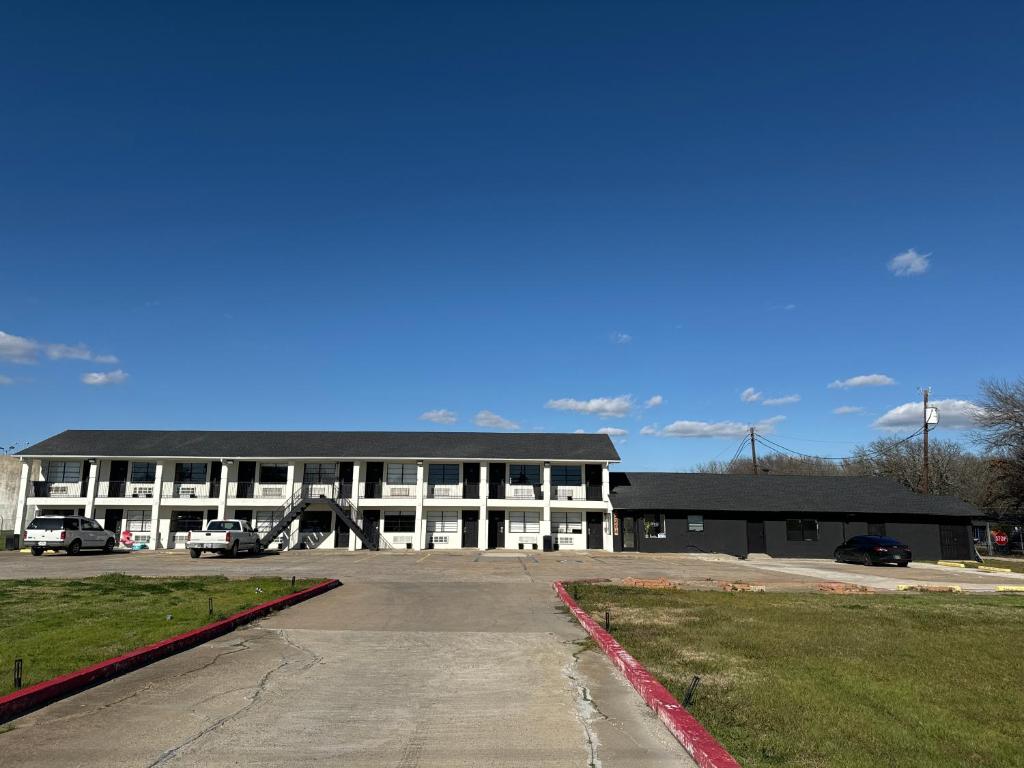 um grande edifício com um parque de estacionamento em frente em Eagle Inn em Gun Barrel City