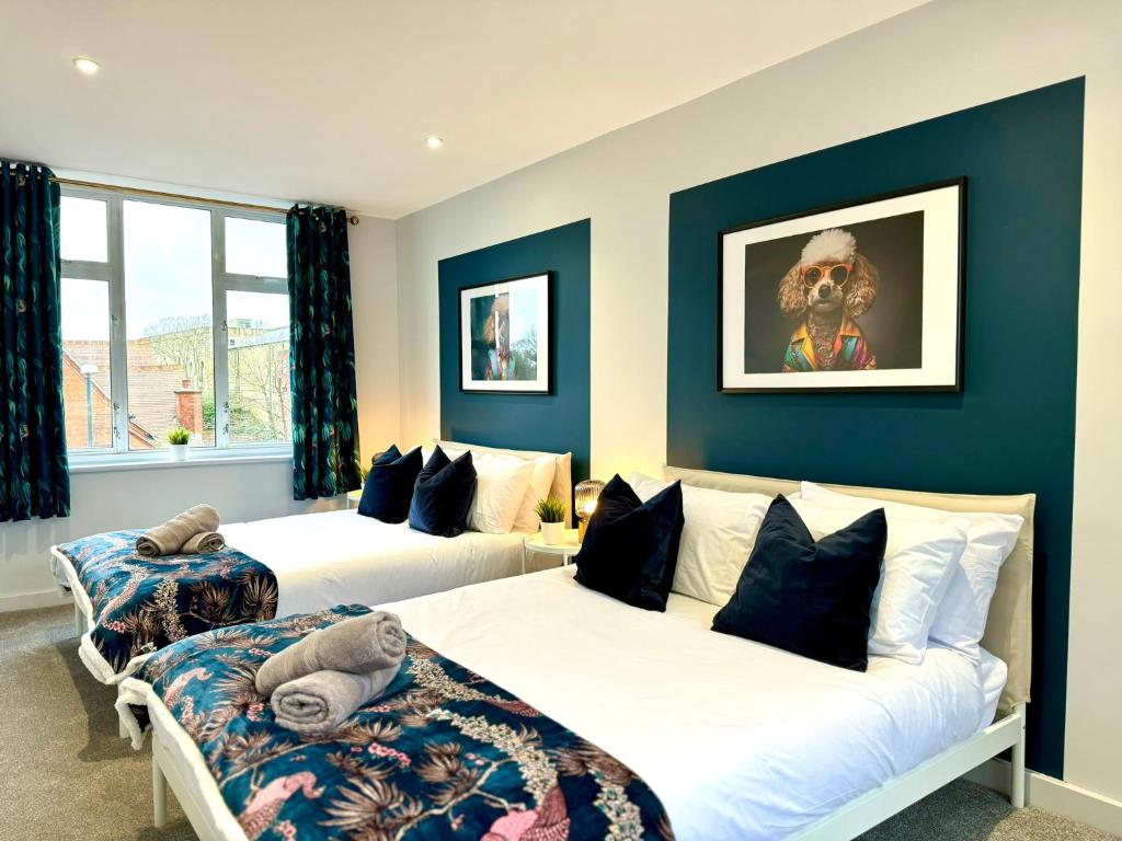 Duas camas num quarto com paredes azuis em Amazing Large 3 Bedroom Apartment - Sleeps 8! em Bournemouth