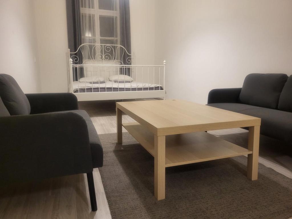 uma sala de estar com uma mesa de centro e 2 cadeiras em Sleepover City Center Apartment em Budapeste