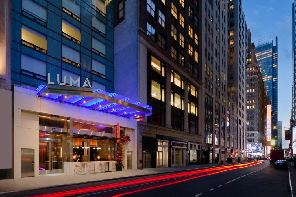 LUMA Hotel - Times Square في نيويورك: شارع المدينة في الليل مع مبنى loma