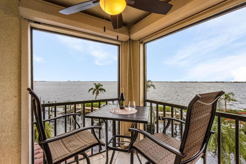 a balcony with a table and chairs and a view of the water at RIVERFRONT VIEW, Stunning Sunrises, Community Pool - Condo Waterfront Sunrise - Roelens in Cape Coral