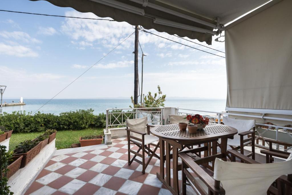 a patio with a table and chairs and the ocean at Pefkohori Blue View by Luxlikehome in Pefkochori