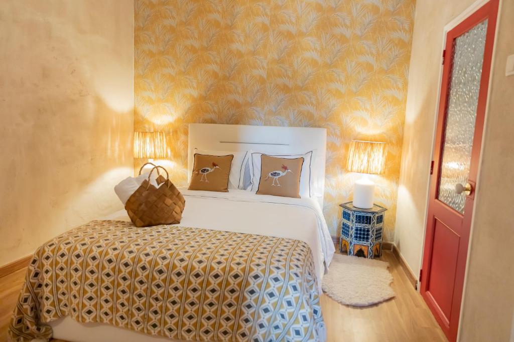 a bedroom with a white bed with a yellow wall at Portas da Cidade Home in Silves