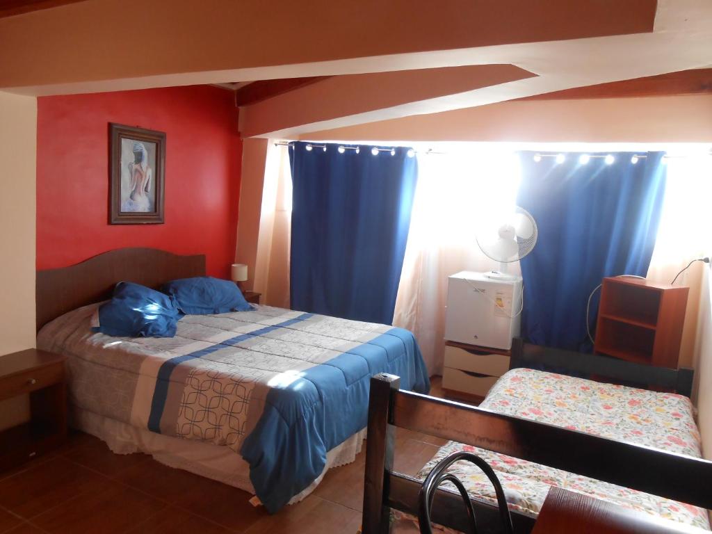 1 dormitorio con 1 cama y cortinas azules en Hospedaje familiar, en Viña del Mar