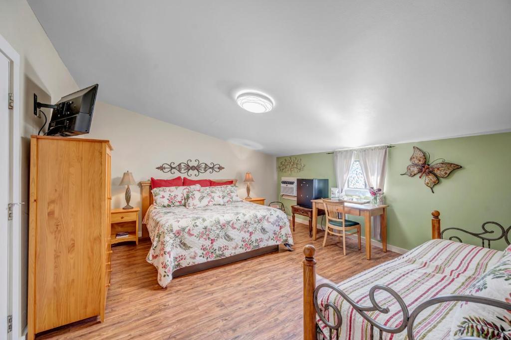 a bedroom with a bed and a desk and a tv at Full Moon Inn in Fredericksburg