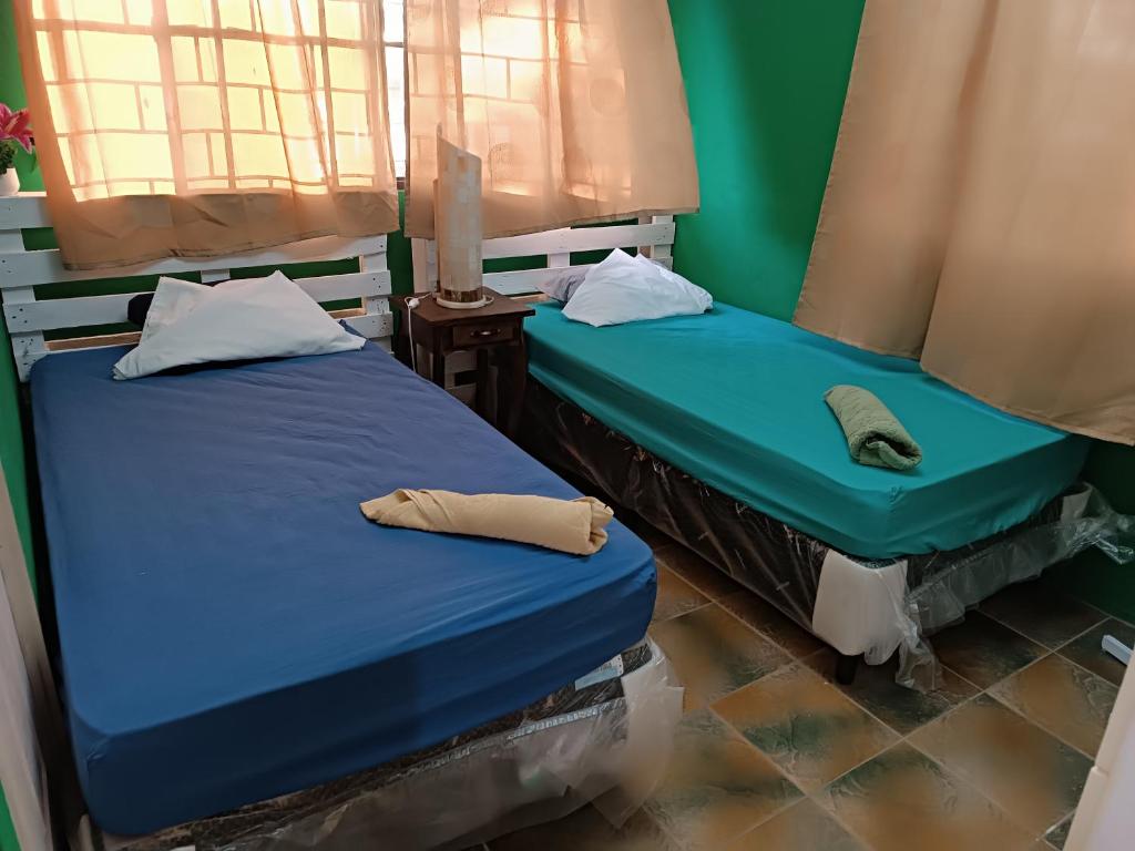 twee bedden naast elkaar in een kamer bij Quinta El Espino in Ahuachapán