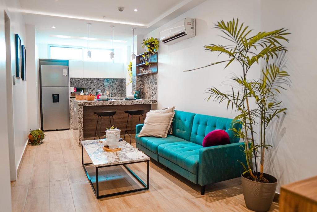 een woonkamer met een blauwe bank en een tafel bij Luxury Apartment estilo Berlin, de estreno in Guayaquil