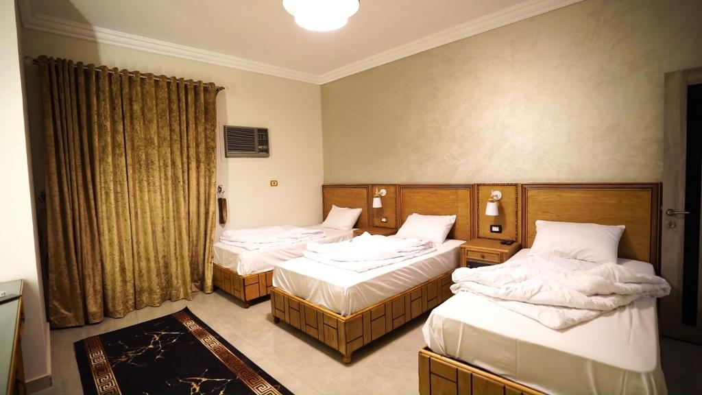 ein Hotelzimmer mit 2 Betten und einem Fenster in der Unterkunft Malaz Qaroun - ملاذ قارون in Qaryat at Ta‘mīr as Siyāḩīyah