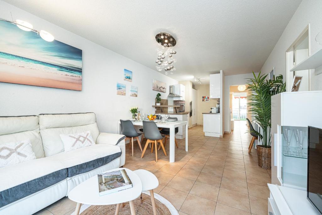 a living room with a couch and a table at Intercontinental Superbe appartement avec piscine in Menton