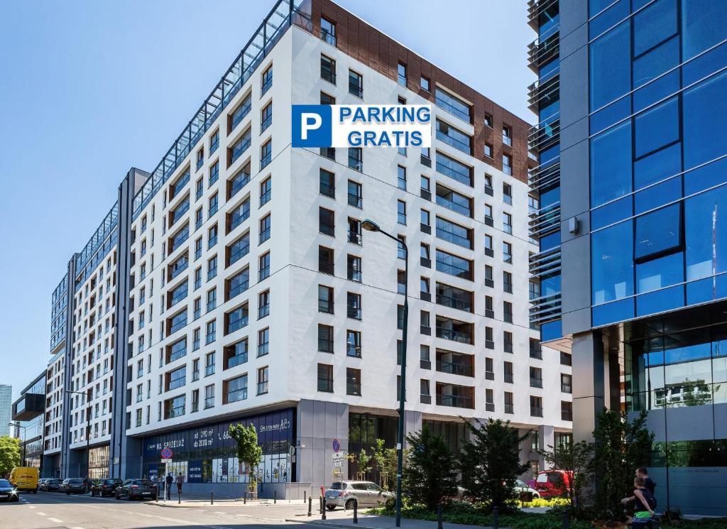 un gran edificio blanco con un cartel de permisos de estacionamiento en Vista Residence Spire en Varsovia